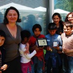 foto di gruppo bambini rom con premio e operatrici Coop Ermes